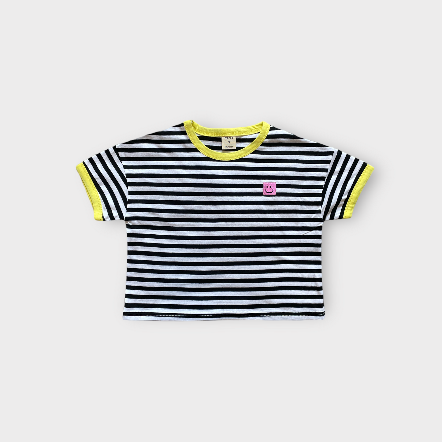 front view striped black oversized kids tee yellow trim pink smiley patch