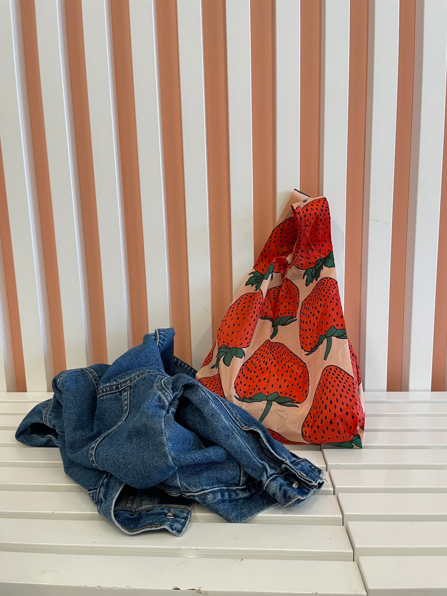 baby baggu reusable bag big red strawberries 100% recycled nylon small mini next to denim jacket on bench